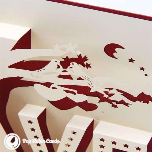 Pop-up love tree with two birds above cream star-cut letters spelling LOVE, and red hearts spiralling down the card