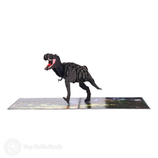 Pop-up T-Rex dinosaur with open jaws and a striped body of layered card, striding across a printed woodland floor of ferns.