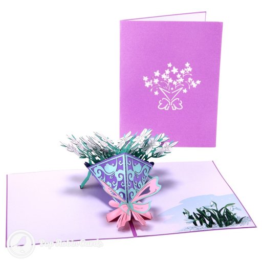 Pop-up bouquet of white flowers in a purple cone with a pink bow, beside printed snowdrops on the right-hand page